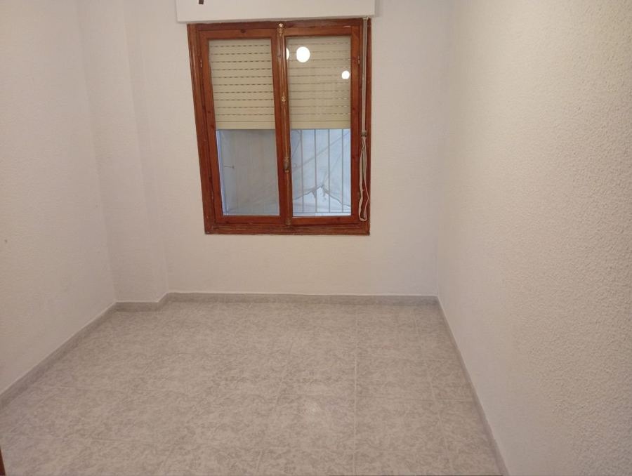 Habitación reformada con suelo nuevo y ventana de madera