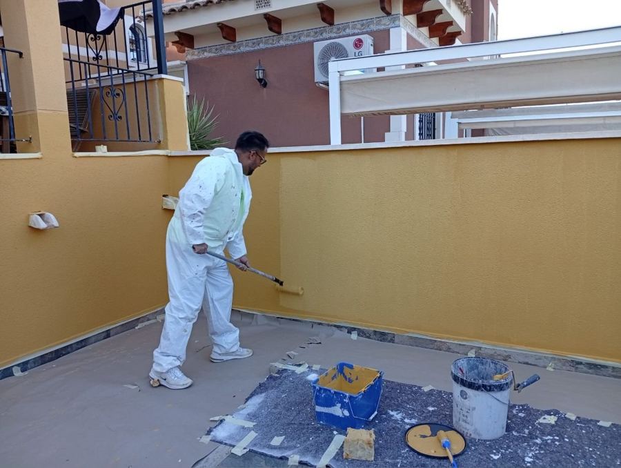 Profesional pintando la fachada de una terraza